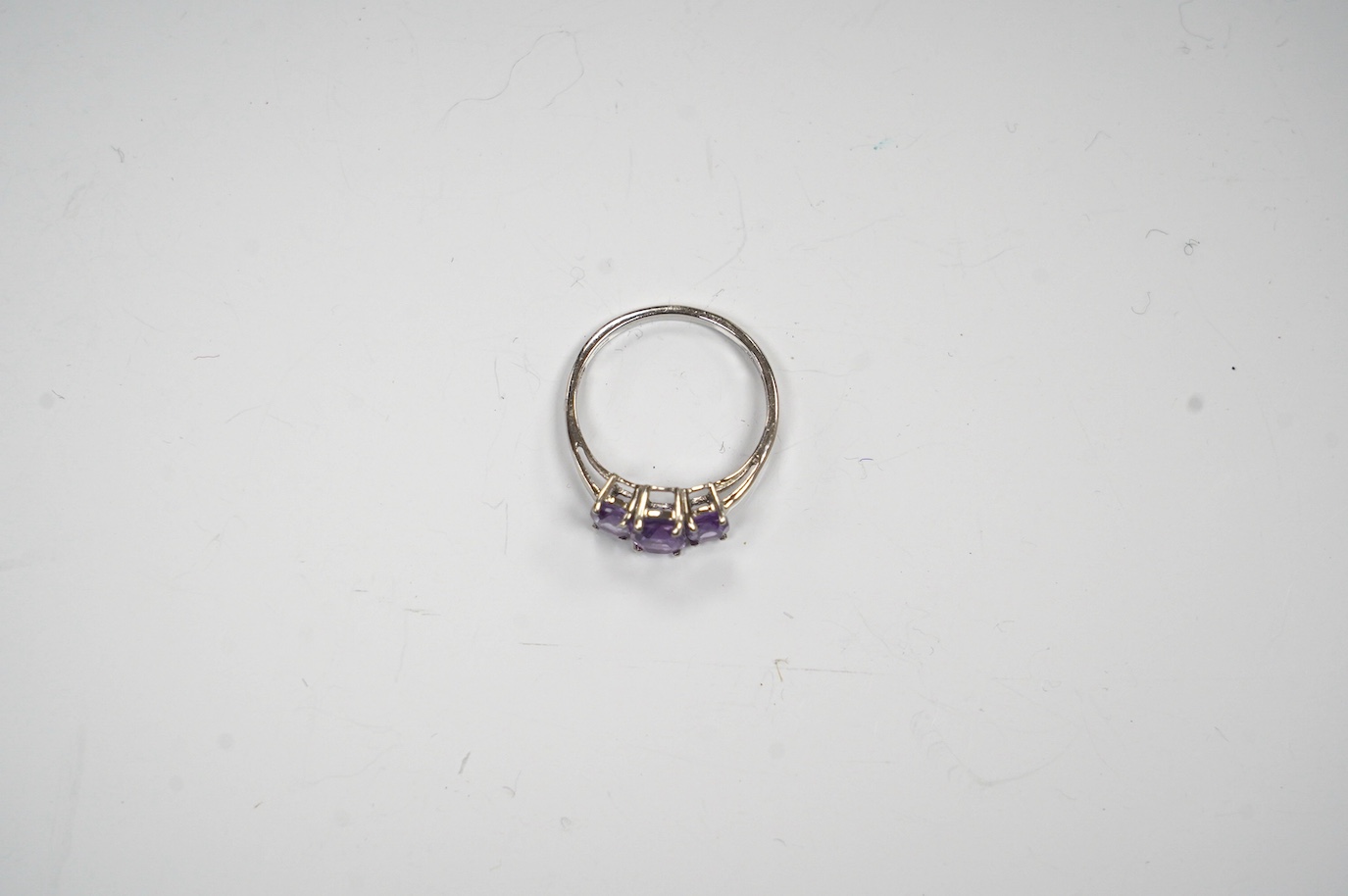 A modern 9ct gold and graduated three stone amethyst set dress ring, size O, gross weight 2.1 grams. Condition - fair to good